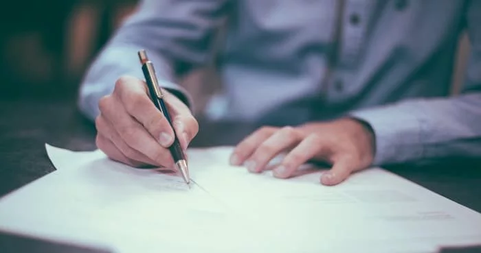 A person carefully comparing Will Writing Services East Sussex options on a clipboard or laptop